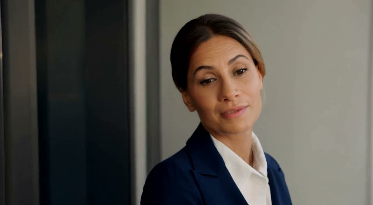 A woman in a navy suit at an office doorway